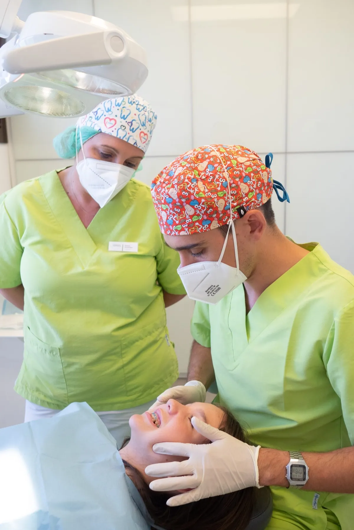 Dos profesionales de Clínica Dental Romeo colocando ortodoncia a una paciente